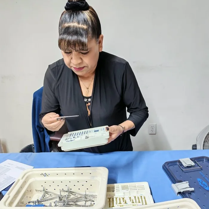 Colaboradora de Kuracis revisando una charola de implantes antes de entregarla
